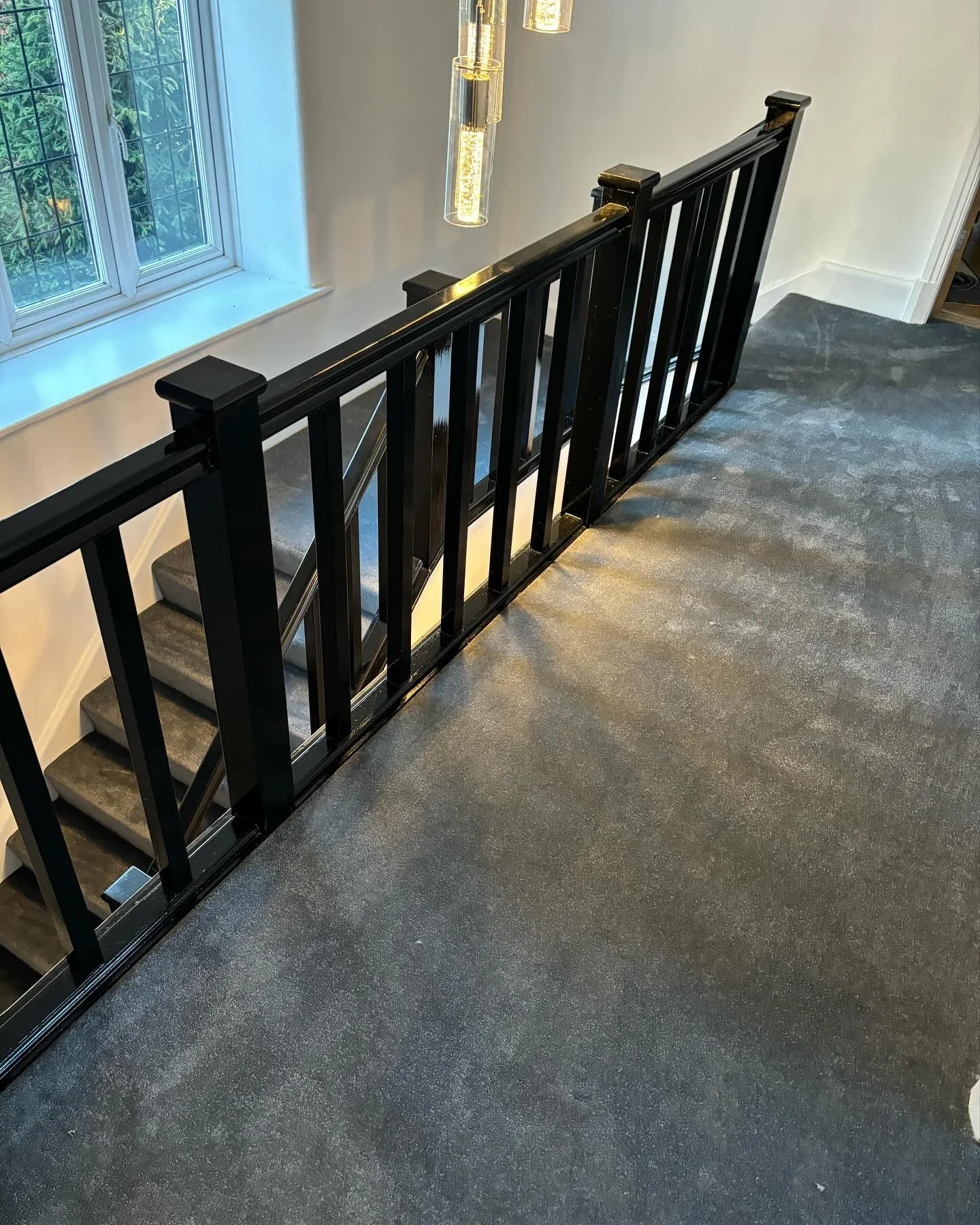 Grey carpet on a landing beside a dark balustrade