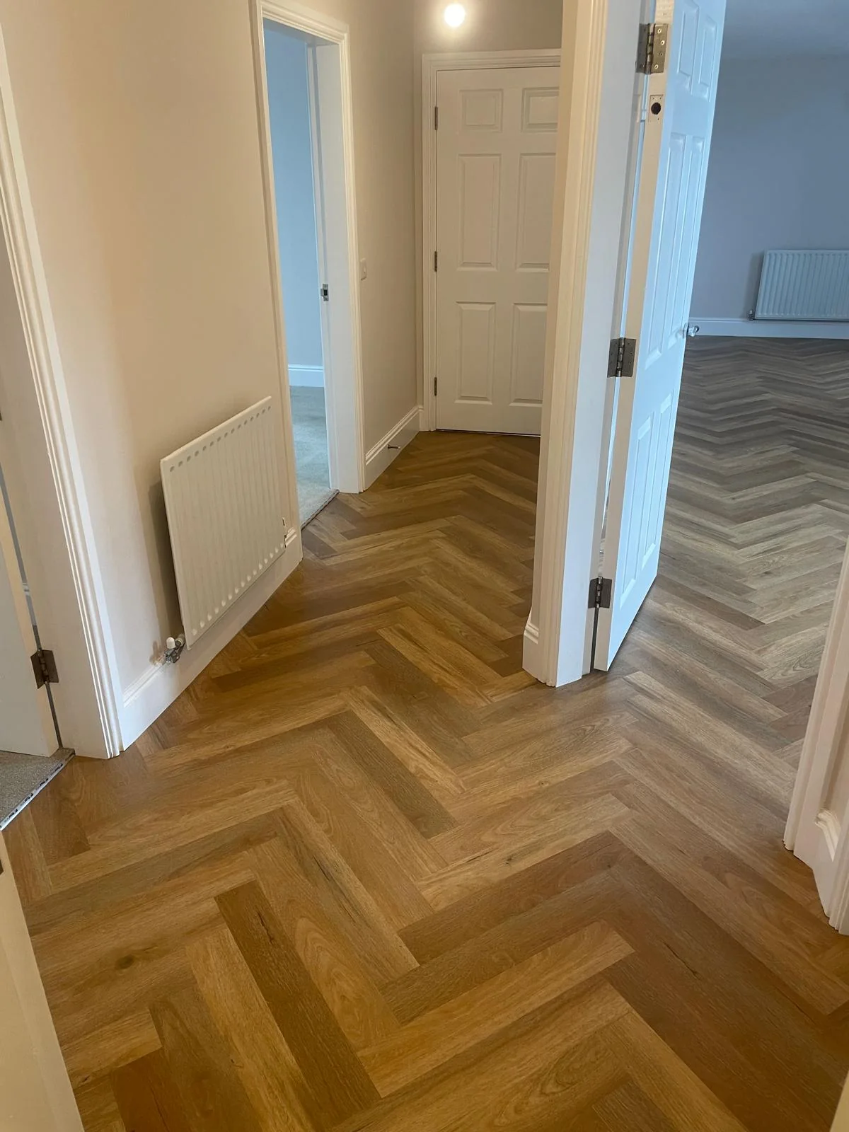 Herringbone flooring flowing through a hallway